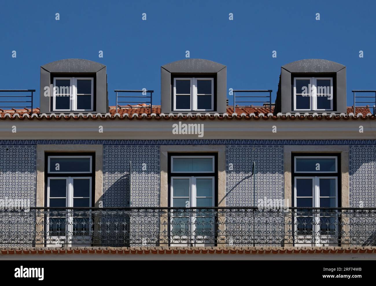 Finestre e piastrelle di un edificio a Lisbona, Portogallo, contro il cielo blu Foto Stock