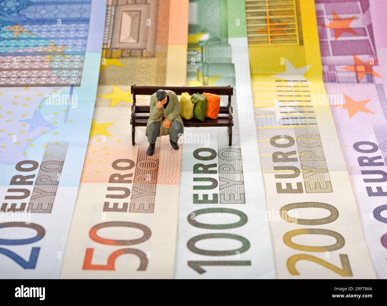 Diversi EURO-Banknoten, Fächer, Figur, Obdachloser, Parkbank, Symbolbild EURO-Krise, inflation, Privatinsolvenz, Parkbank, Foto Stock