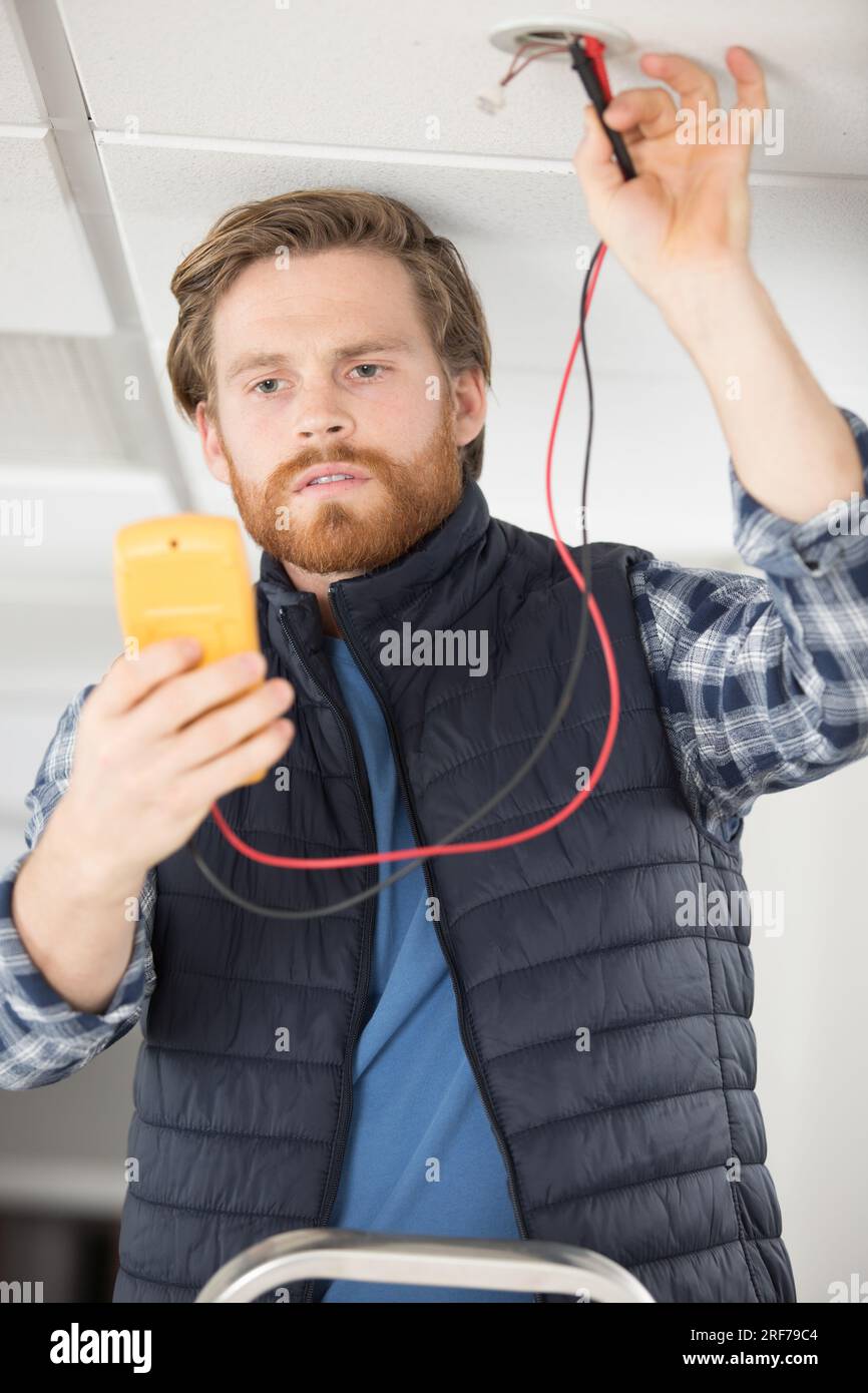 Elettricista è fissare un elettrico tubo corrugato Foto Stock