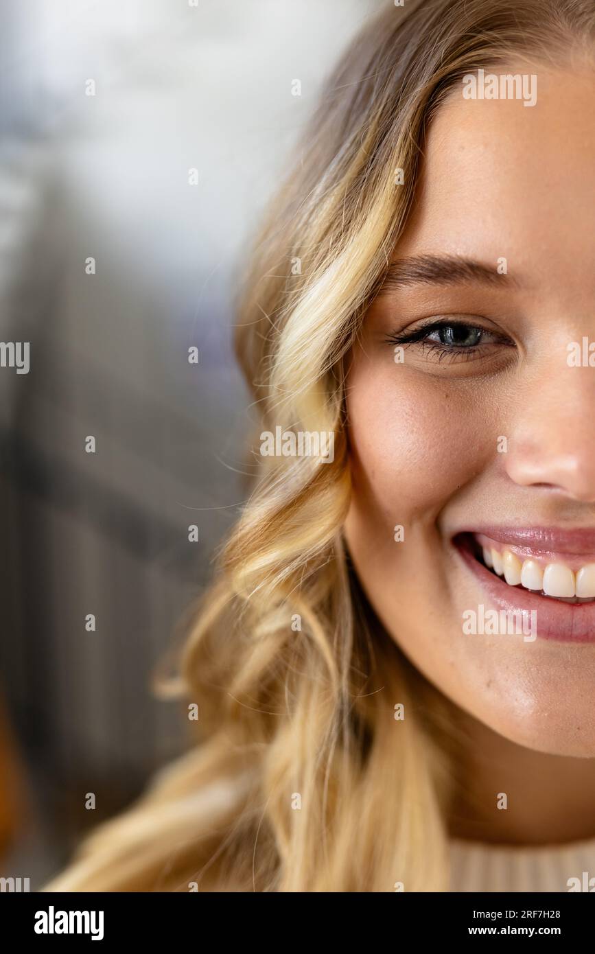 Ritratto di donna caucasica felice con lunghi capelli biondi a casa Foto Stock