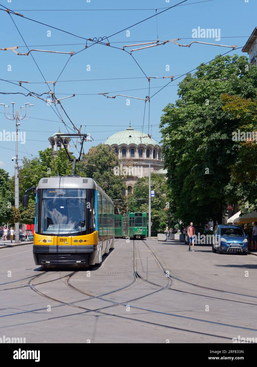 Chiesa della Cattedrale di Sveta Nedelya (Ortodossa Orientale) con un tram giallo, noto anche come tram, città di Sofia, Bulgaria. 1° agosto 2023. Foto Stock