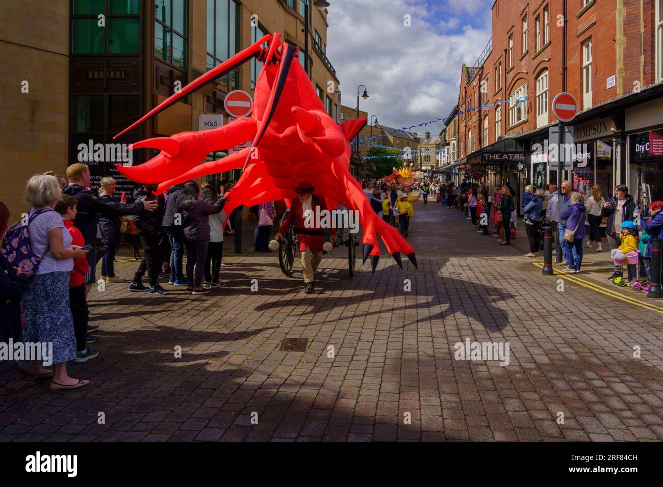 Una gigantesca aragosta gonfiabile rossa attira gli spettatori nel centro della città alla Harrogate Carnival Parade nel North Yorkshire, Inghilterra, Regno Unito. Foto Stock