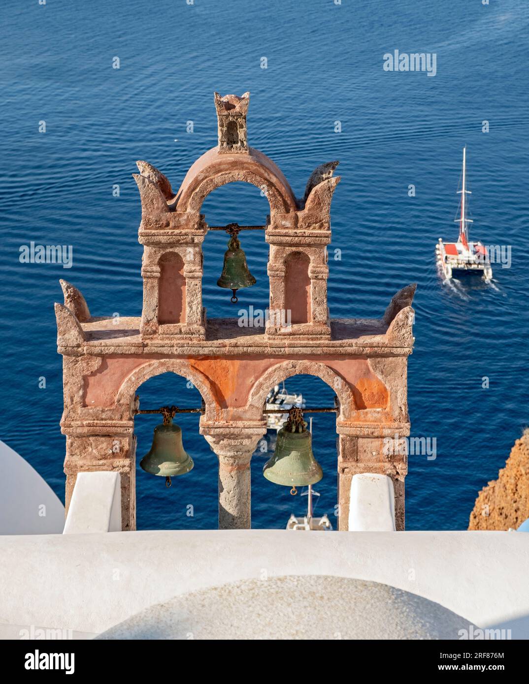 Vecchio campanile con yacht e mare blu, Ia (Oia), Santorini, Grecia Foto Stock