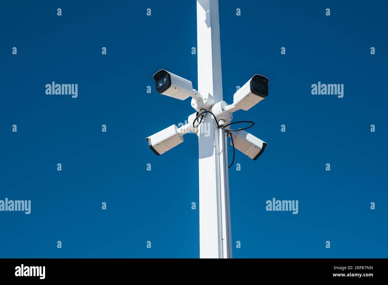 Videocamere di sicurezza su un palo su sfondo blu Foto Stock