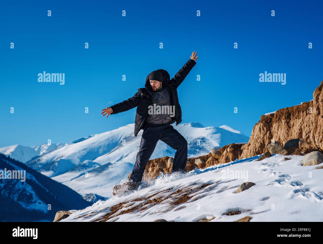 Giovane turista che scivola giù dalla montagna durante la stagione invernale Foto Stock