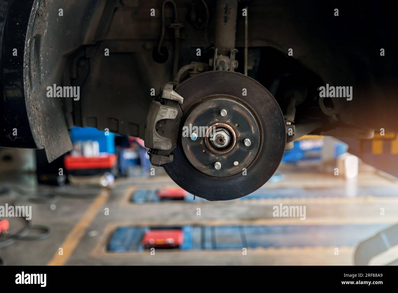 Manutenzione del freno a disco della vettura in corso di sostituzione di un nuovo pneumatico presso la stazione di servizio di riparazione. Foto Stock