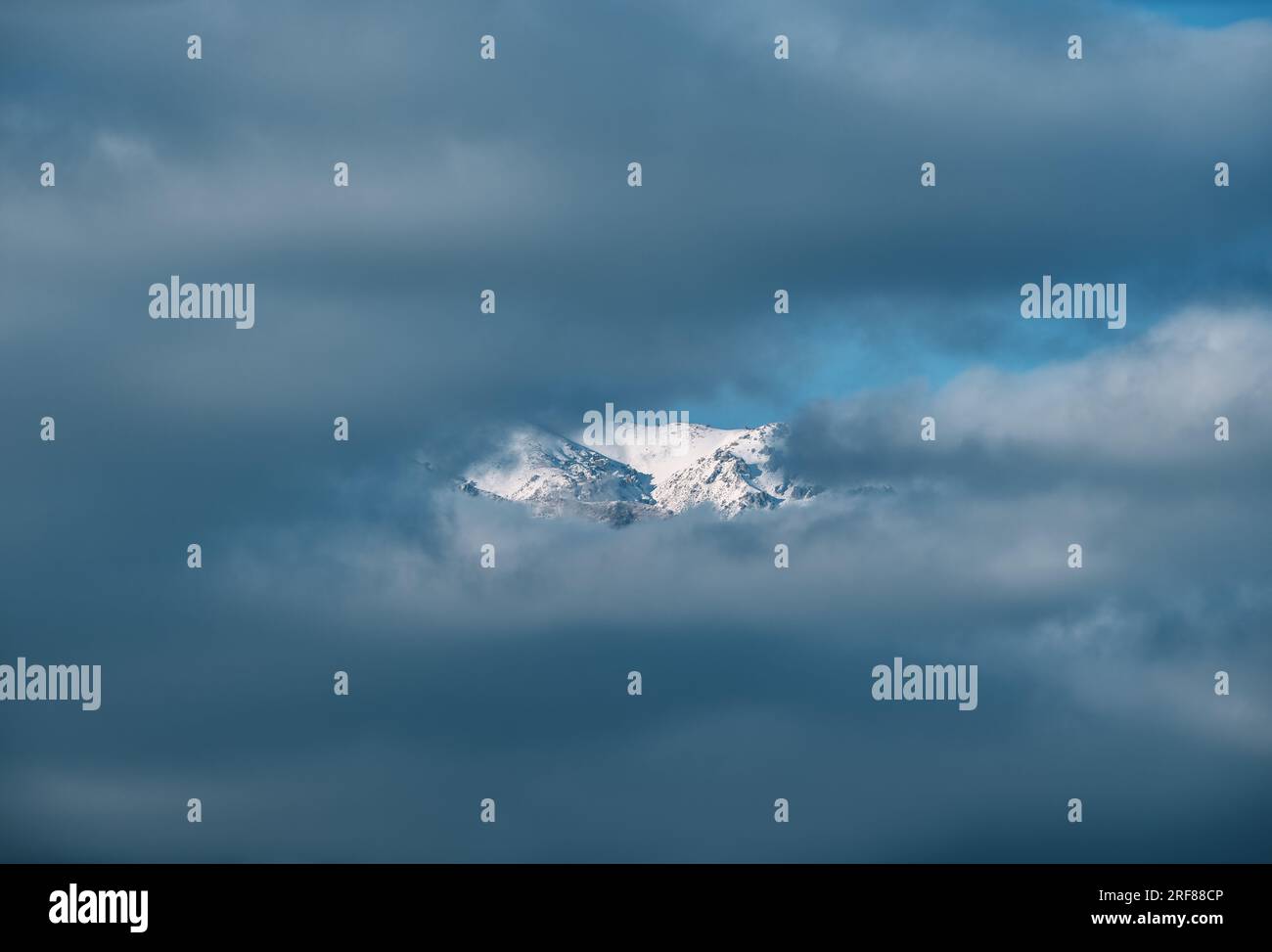 Le montagne si affacciano attraverso le nuvole Foto Stock
