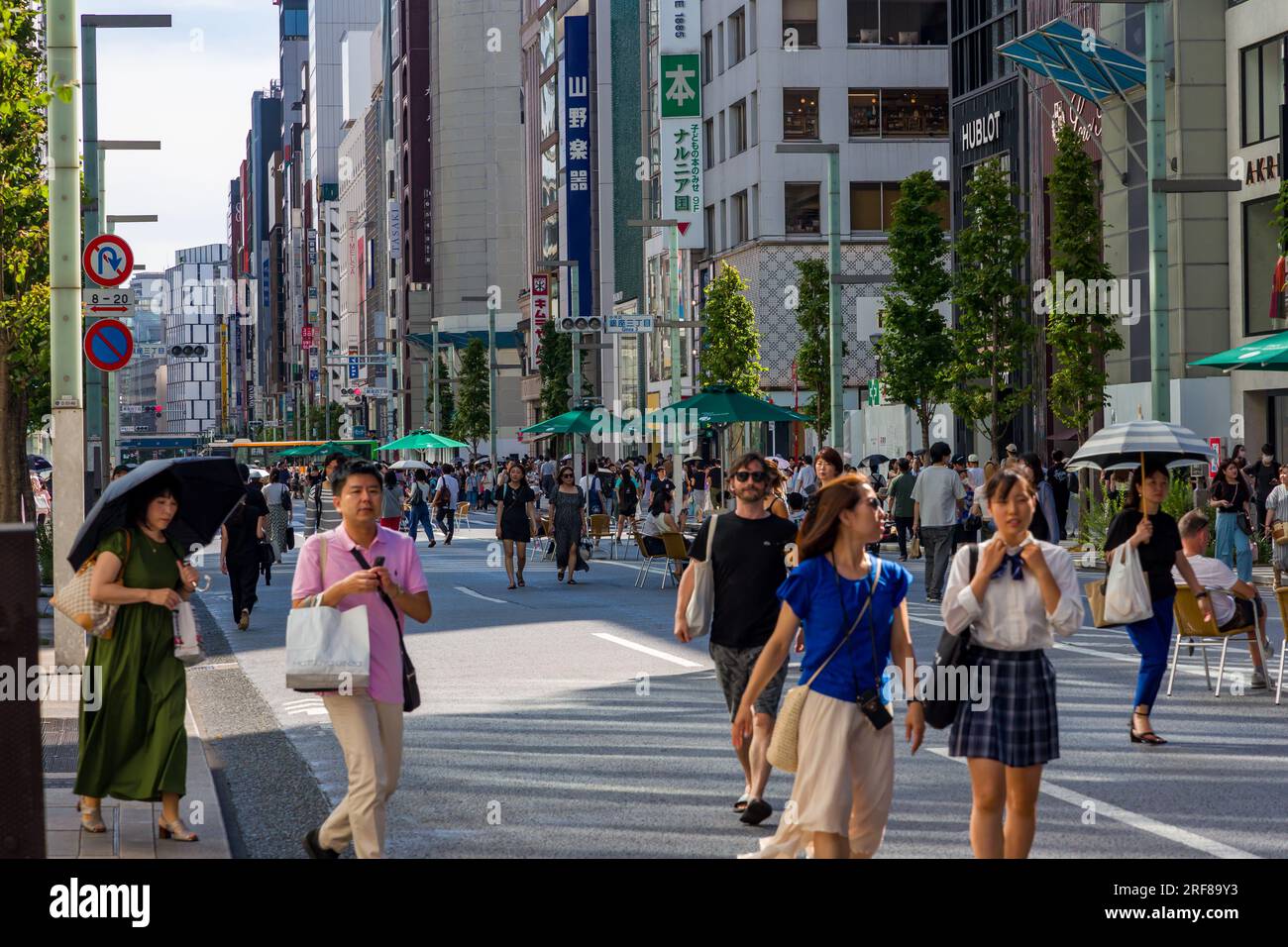 TOKYO, GIAPPONE - LUGLIO 30 2023: Gli acquirenti sulle strade chiuse di Ginza, il quartiere dei negozi di lusso del centro di Tokyo Foto Stock