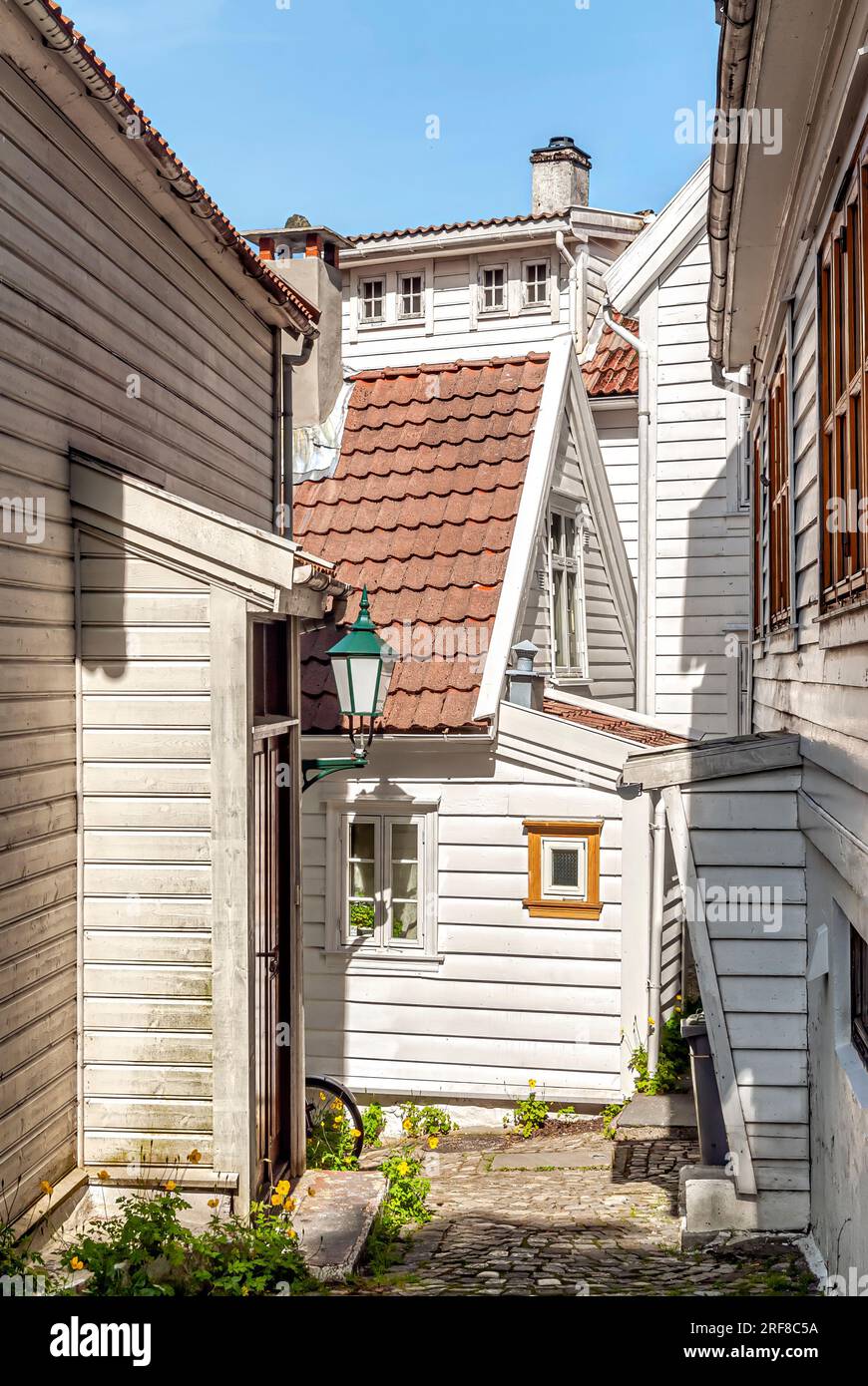 Stretta entrata delle storiche case Weatherboard presso lo storico quartiere Nordnes di Bergen, Norvegia Foto Stock