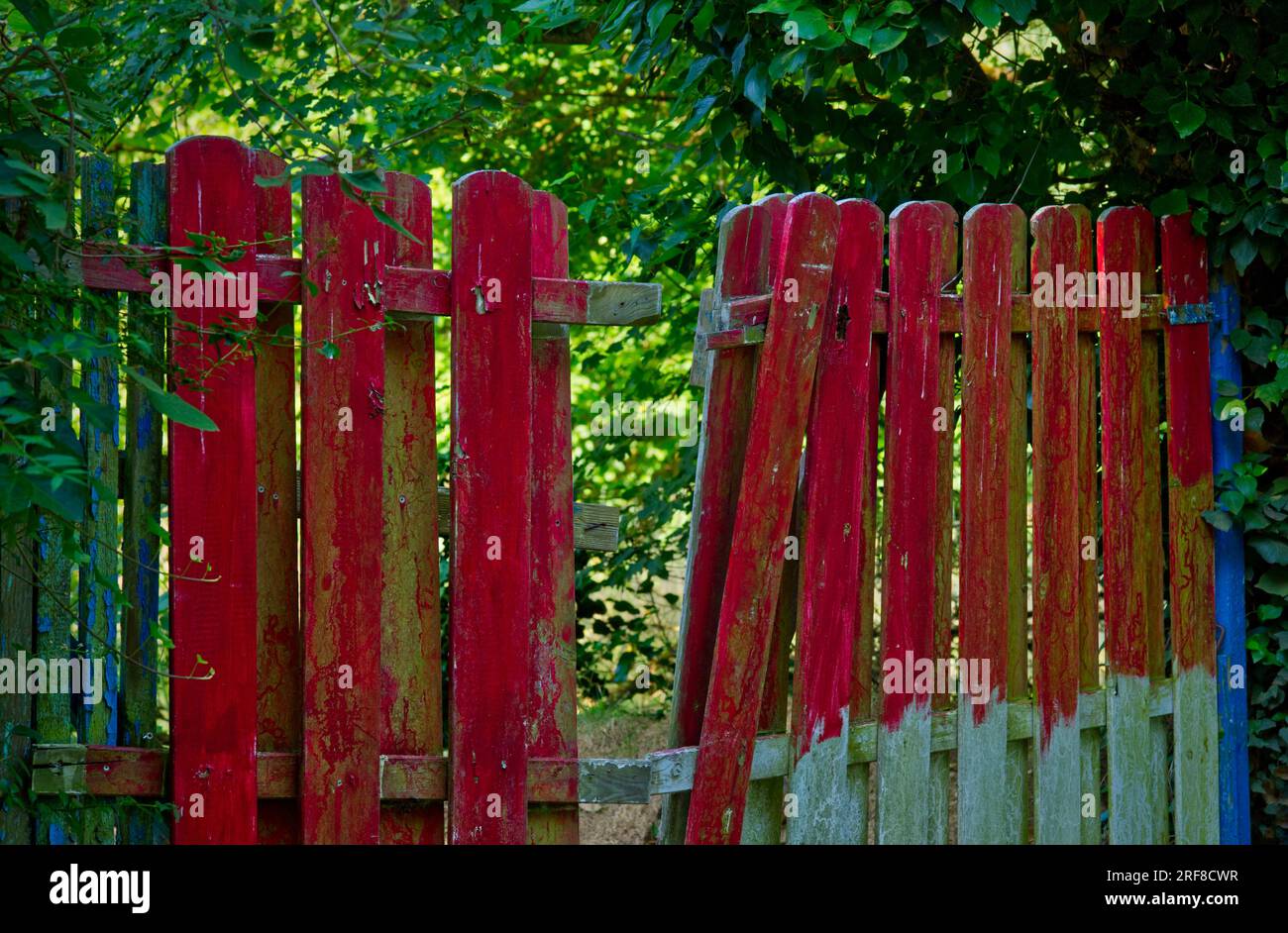 Una recinzione della tavola dipinta di rosso con uno spazio al centro Foto Stock