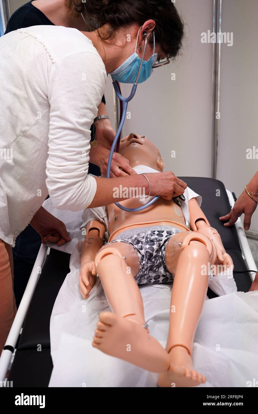 I medici generici sono addestrati alle procedure di emergenza pediatrica. Un medico svolge il ruolo della madre durante l'intervento. Foto Stock