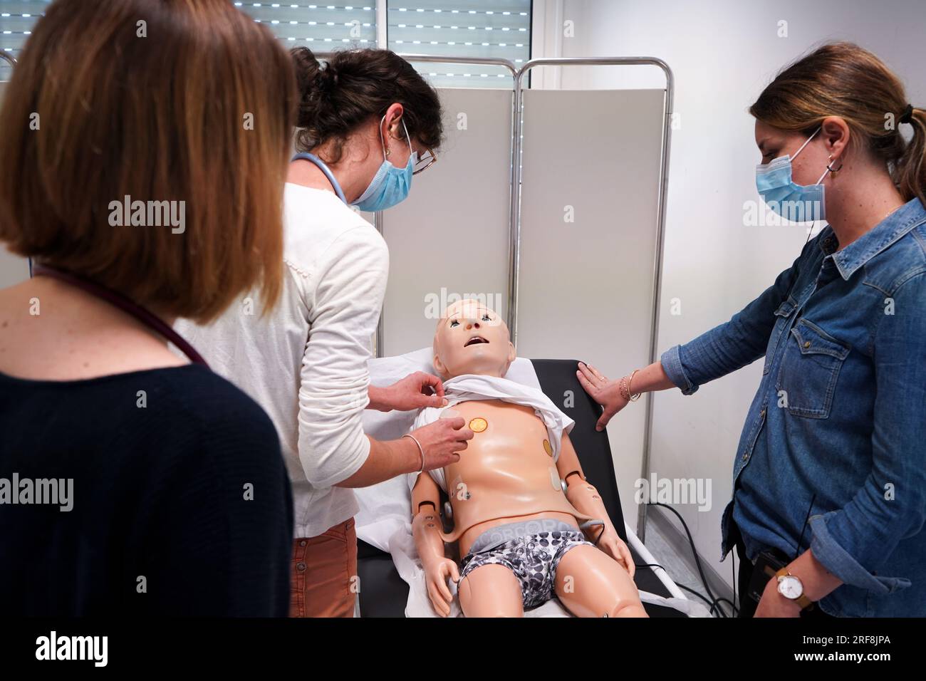 I medici generici sono addestrati alle procedure di emergenza pediatrica. Un medico svolge il ruolo della madre durante l'intervento. Foto Stock