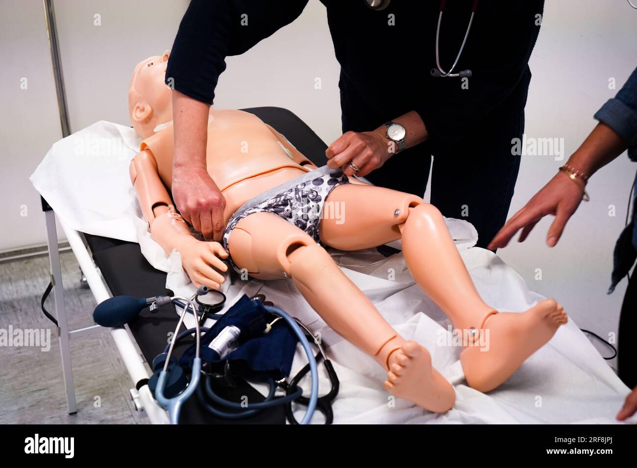 I medici generici sono addestrati alle procedure di emergenza pediatrica. Un medico svolge il ruolo della madre durante l'intervento. Foto Stock