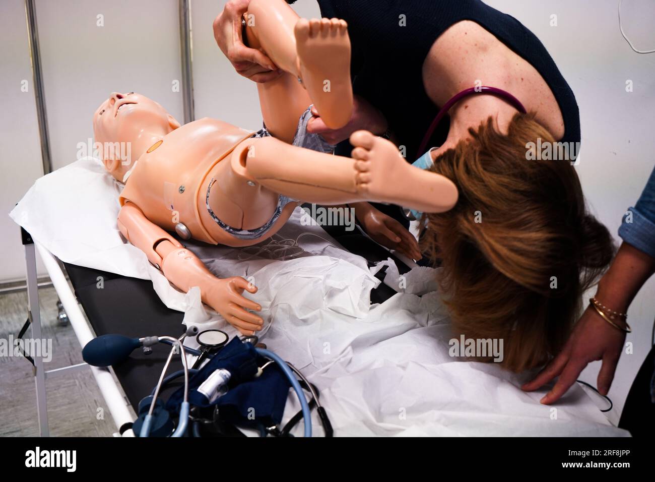 I medici generici sono addestrati alle procedure di emergenza pediatrica. Un medico svolge il ruolo della madre durante l'intervento. Foto Stock