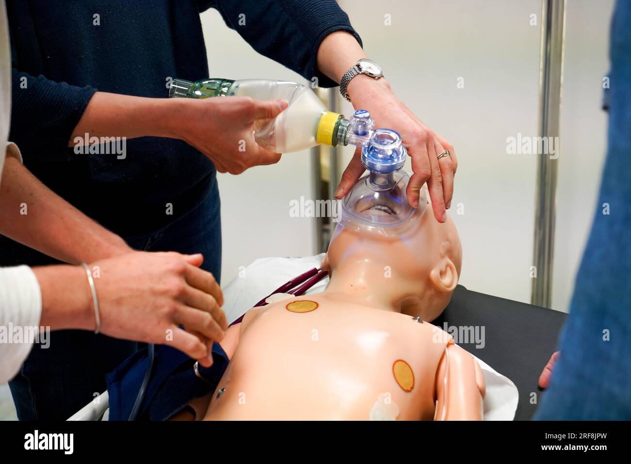 I medici generici sono addestrati alle procedure di emergenza pediatrica. Un medico svolge il ruolo della madre durante l'intervento. Foto Stock