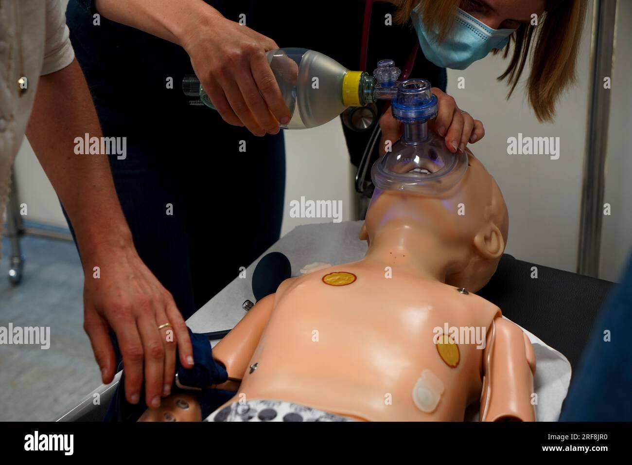 I medici generici sono addestrati alle procedure di emergenza pediatrica. Un medico svolge il ruolo della madre durante l'intervento. Foto Stock