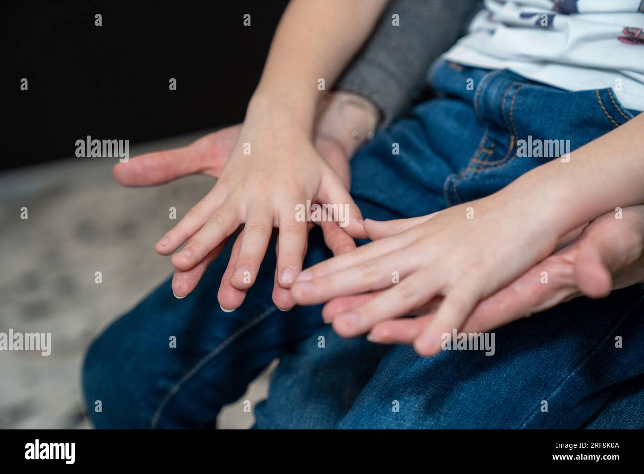Vaccinazione di 5-11 anni. Bambino seduto in braccio a sua madre in attesa di essere vaccinato. Foto Stock