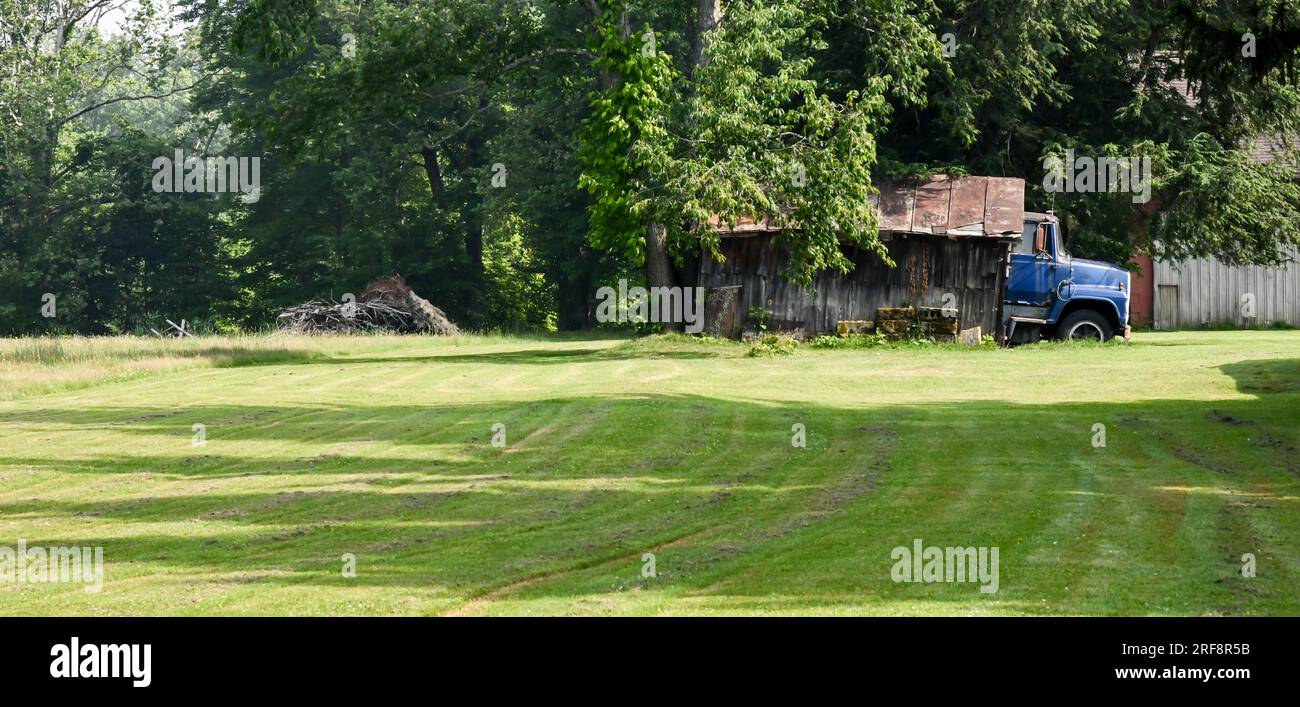Vecchio e abbandonato camion blu in un piccolo capanno agricolo Foto Stock