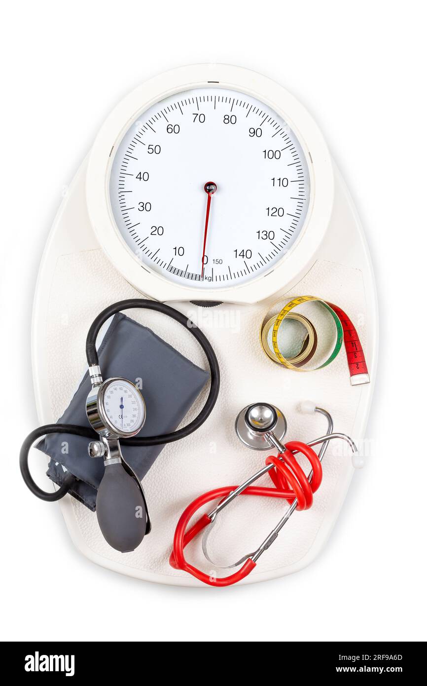 Stetoscopio, tensiometro, metro a nastro per sartoria posizionato su una bilancia per il bagno. Foto Stock
