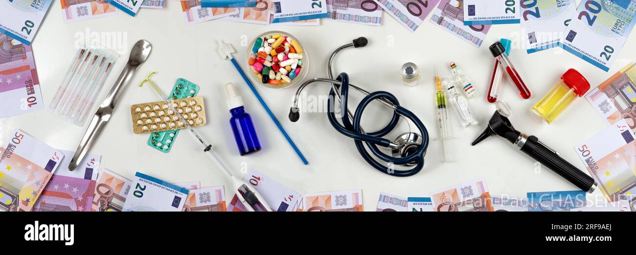 Banconote intorno a medicinali e attrezzature mediche. Foto Stock