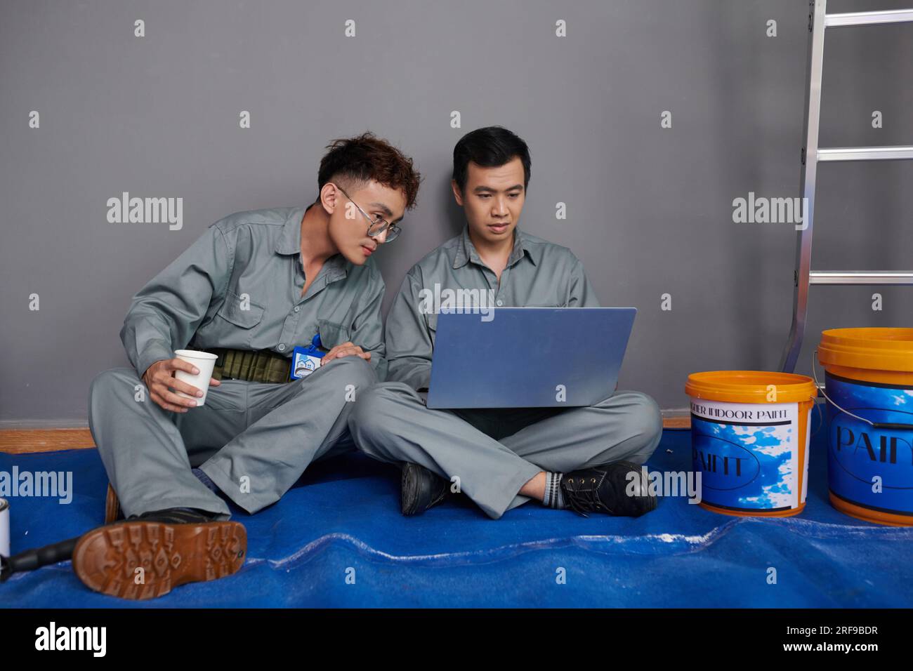 I costruttori leggono le e-mail dei clienti sullo schermo di un notebook durante il pranzo Foto Stock