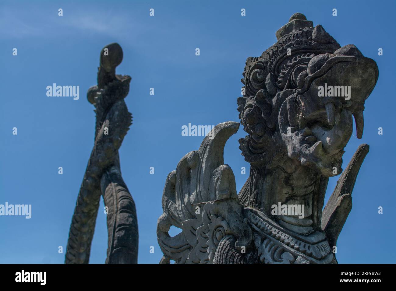 Statue in pietra balinese sull'acqua nel Palazzo dell'acqua del Lago Tirta Gangga a Bali, Indonesia Foto Stock