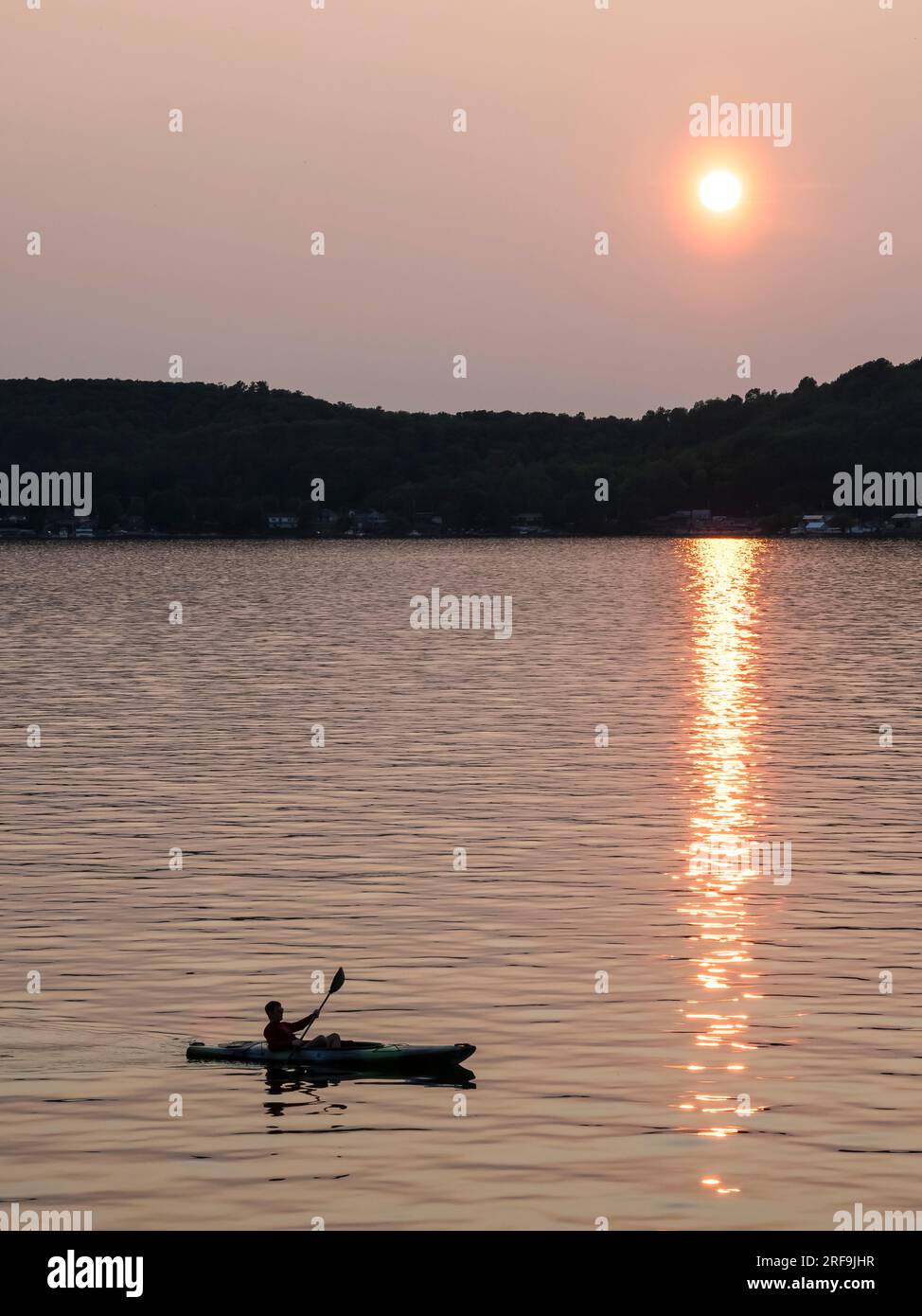 Kayak sul lago Superior con riflessi scintillanti del sole dorato nell'acqua. Foto Stock