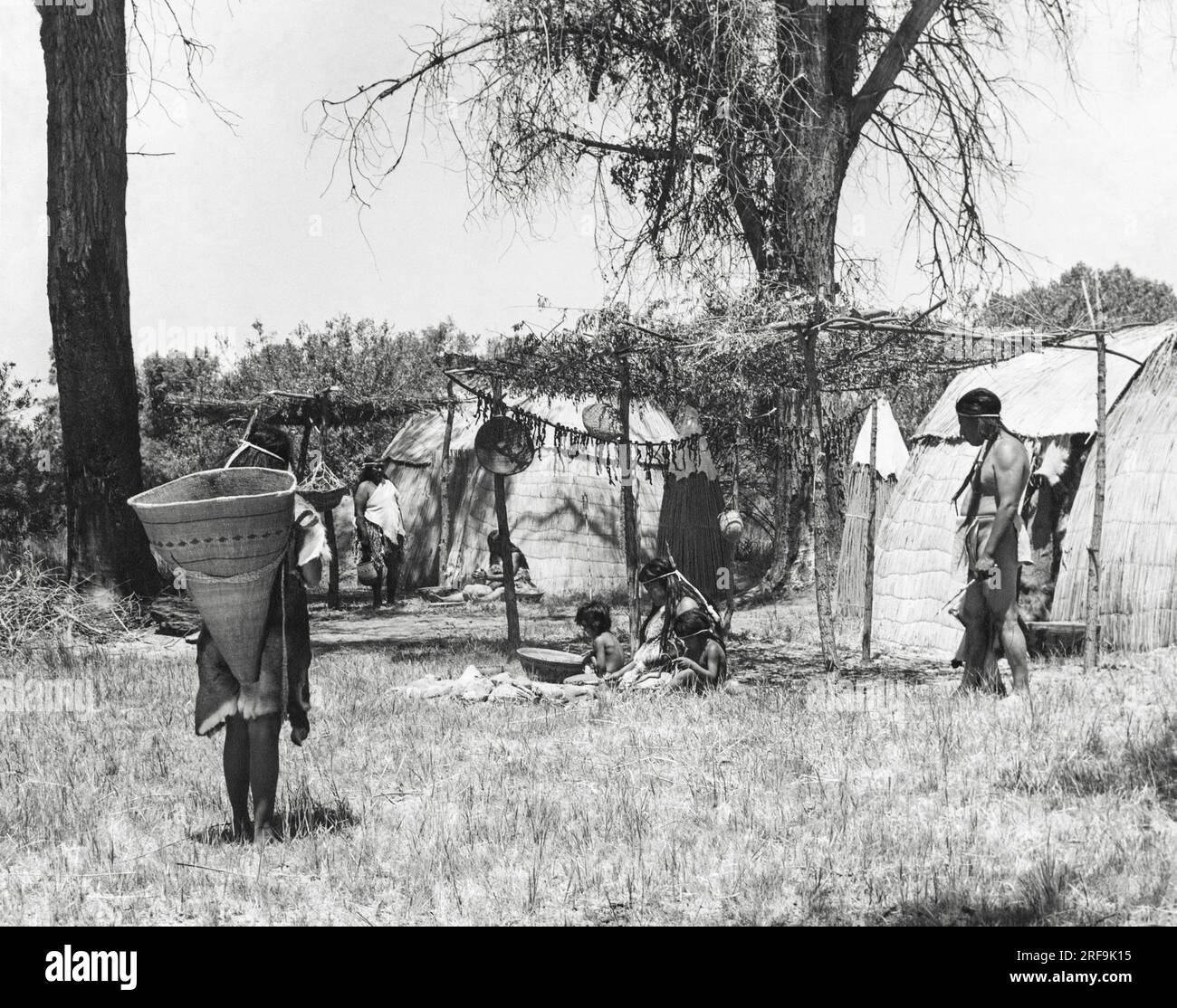 California: circa 1930 i nativi americani della California vivevano in comunità di villaggi che variavano di dimensioni da poche famiglie a diverse centinaia di persone. Gli indiani Yokut della valle di San Joaquin sistemarono le loro case in file ordinate e fecero delle tende solari davanti alle loro case per vivere all'aperto Foto Stock