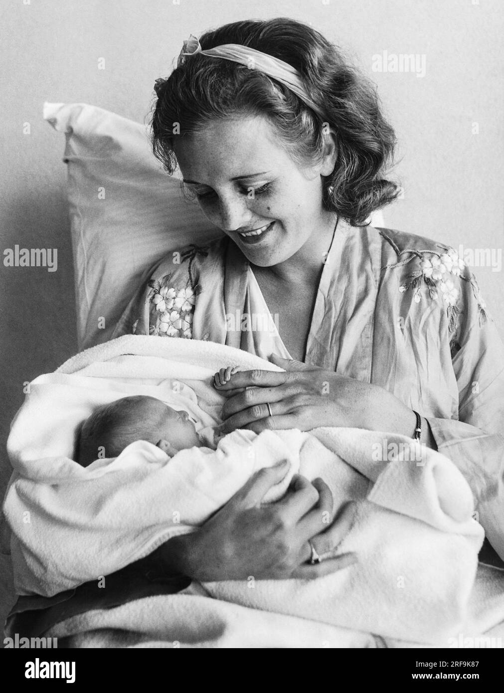 Honolulu, Hawaii: 15 giugno 1932 la neonata Marylyn Hauoli Thorpe mantiene una stretta presa su sua madre, che è ben nota come Mary Astor nei film. Foto Stock