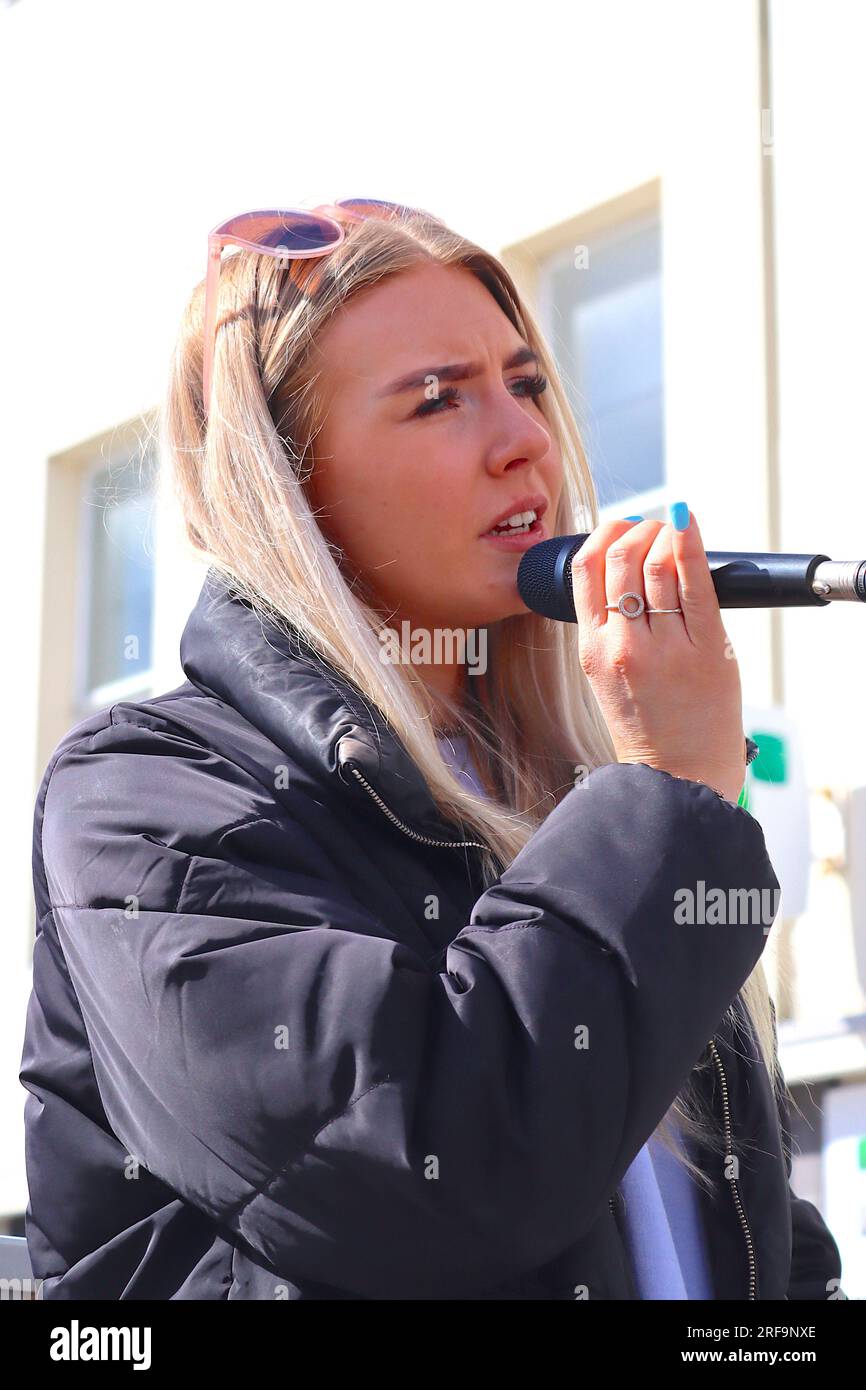 Nancy Longland, una cantante di strada e giovane soprano solista, intrattiene dal vivo gli acquirenti nel distretto, un'area commerciale priva di traffico a Southampton. Foto Stock