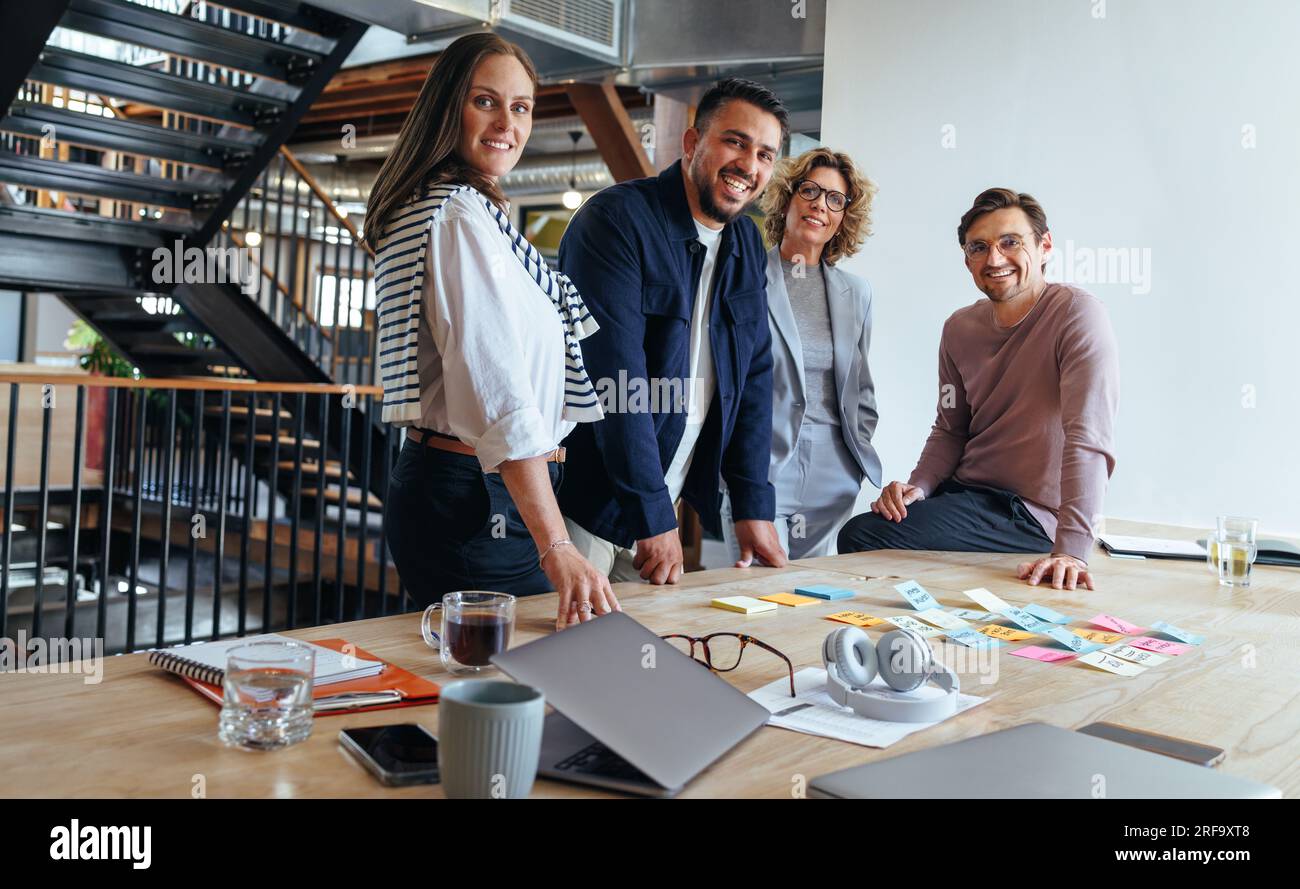 Gruppo di professionisti del marketing che tengono una riunione. Brainstorming creativo del team aziendale con appunti. Gente d'affari felice che mette le proprie idee Foto Stock