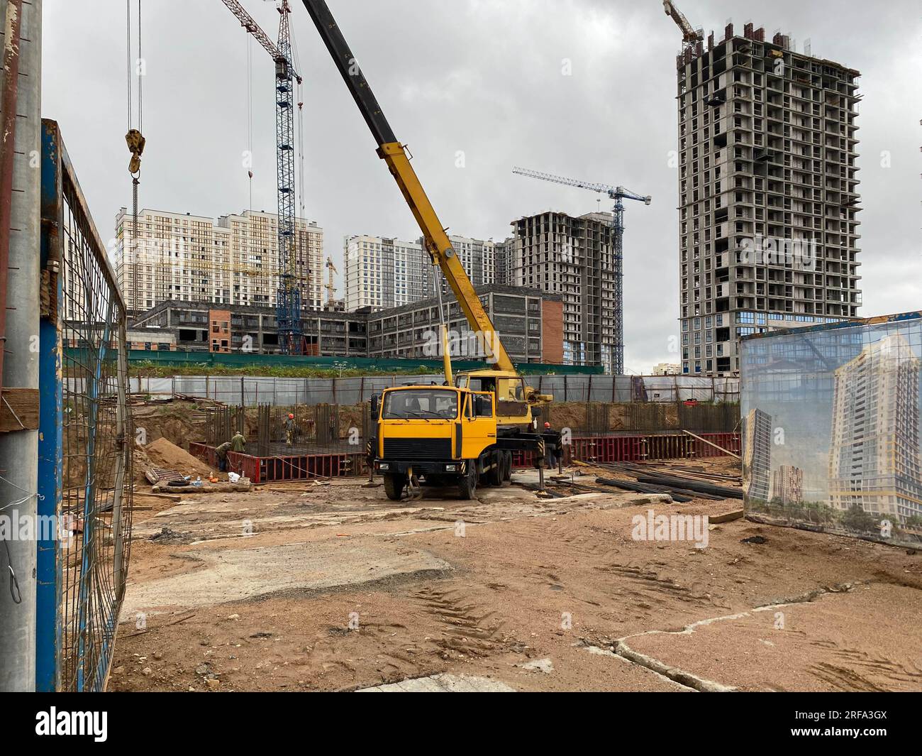 Grande mobilità gialla la moderna gru da costruzione industriale montata su un carrello viene utilizzata per la costruzione di nuove abitazioni, case, edifici in un grande edificio Foto Stock