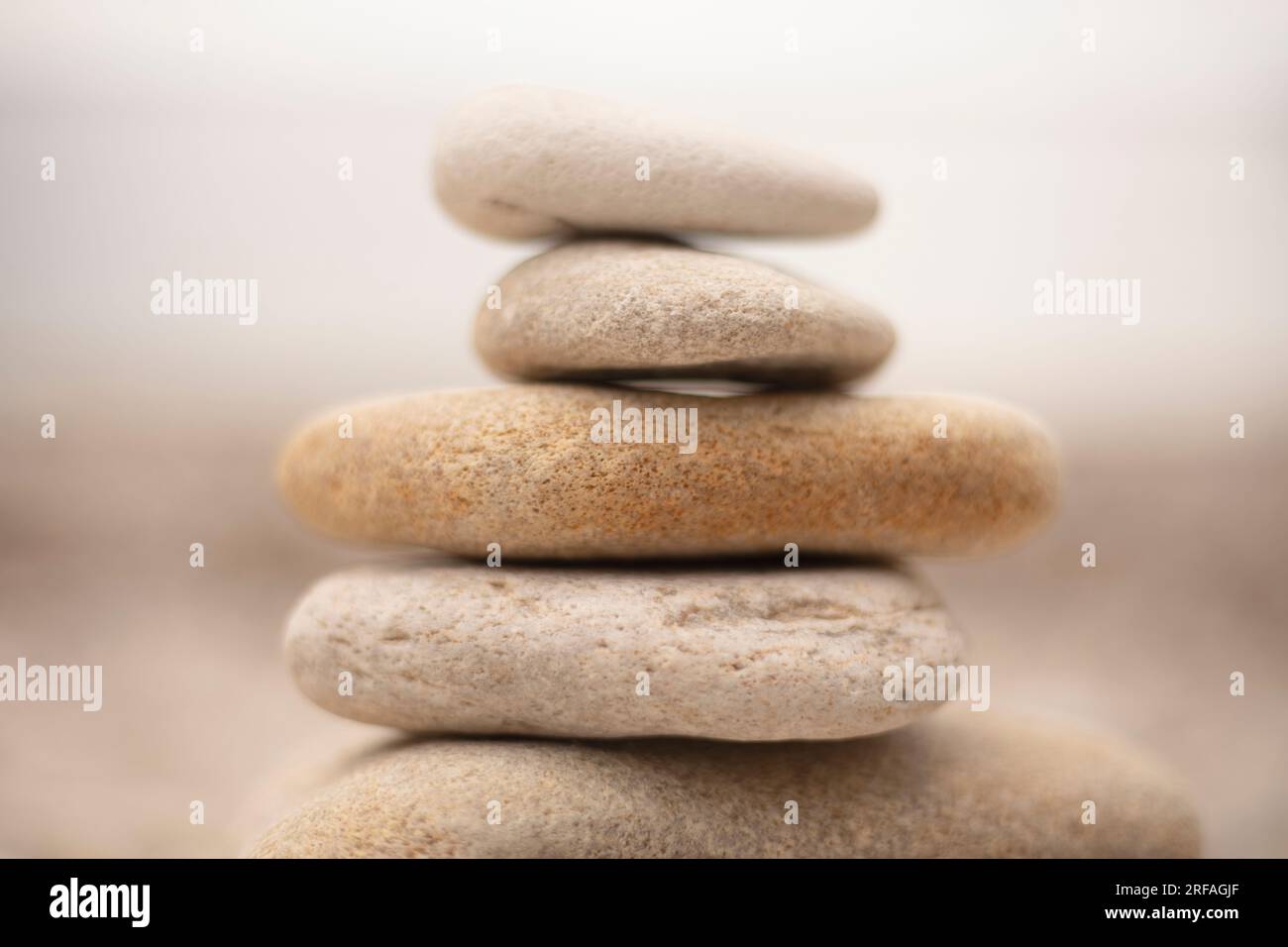 Pile di pietre bianche simili a zen sulla spiaggia che invitano calma e riflessione Foto Stock
