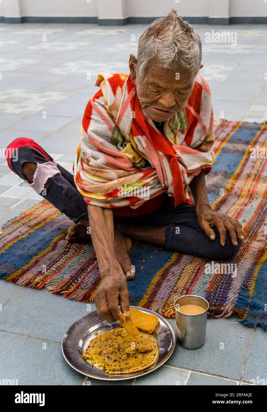 14 ottobre 2022 Uttarakhand, India. Rappresentazione emotiva di un'anziana donna indiana che fa colazione in una desolata casa di vecchiaia. Raffigurazione commovente dell'agin Foto Stock