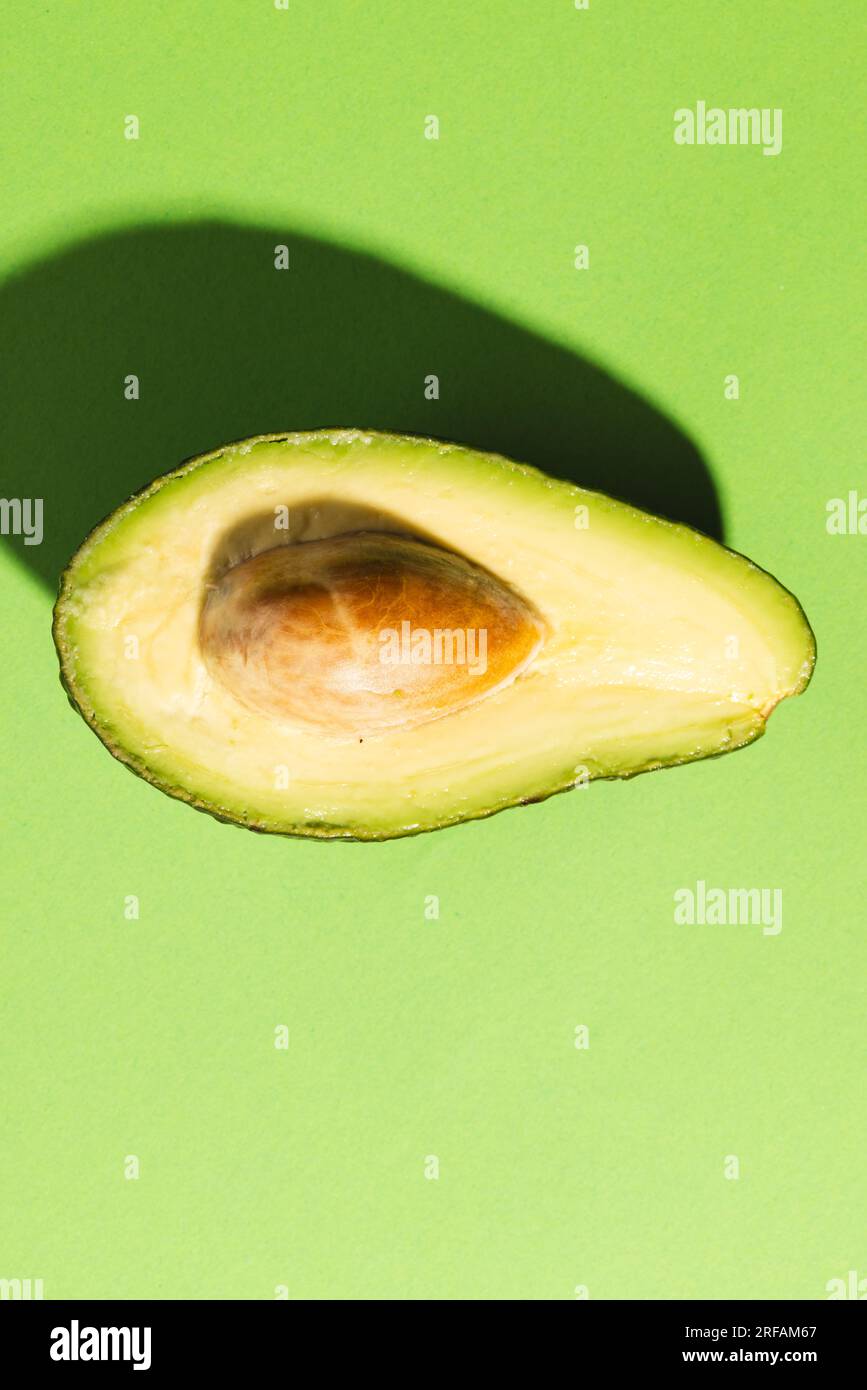 Primo piano dell'avocado dimezzato e dello spazio di copia su sfondo verde Foto Stock