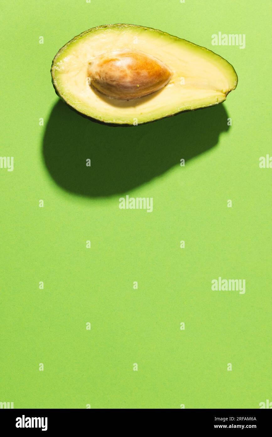 Primo piano dell'avocado dimezzato e dello spazio di copia su sfondo verde Foto Stock