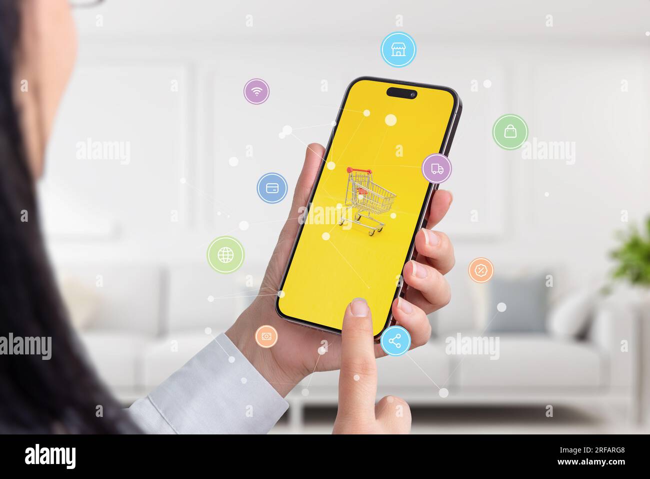 Ragazza che fa shopping online con il concetto di smartphone. Carrello sul display del telefono con icone di shopping volanti e nodi di rete Foto Stock