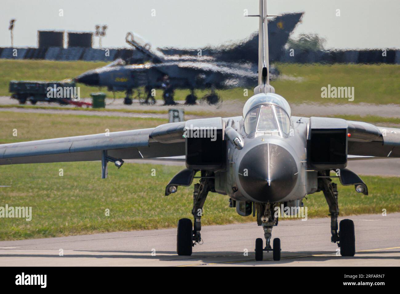 Aerei da caccia RAF Tornado GR4 a reazione presso RAF Waddington, Lincolnshire, Regno Unito. Un jet parcheggiato, un aereo che rullava verso la pista Foto Stock