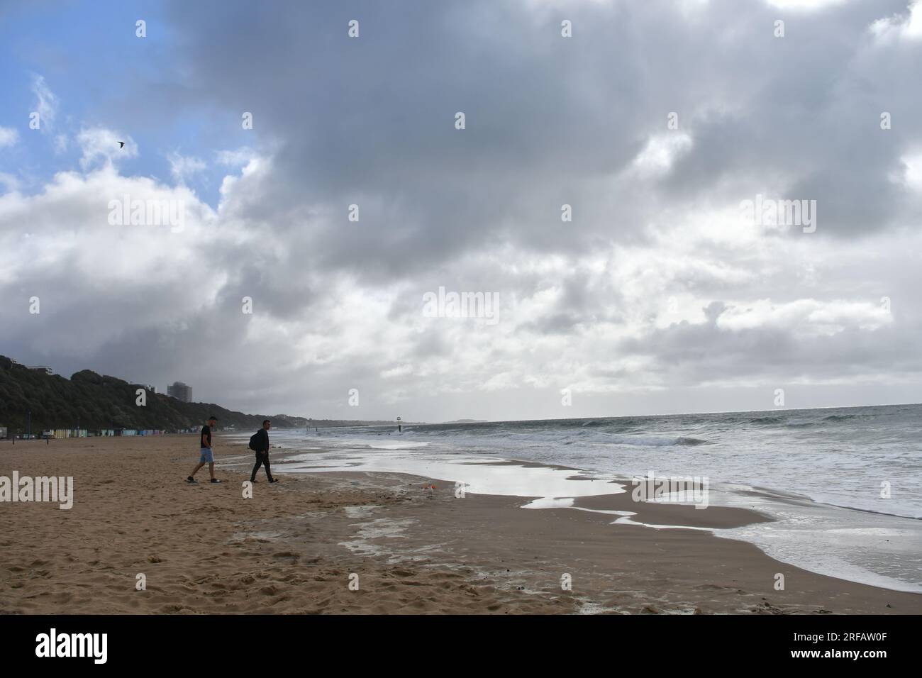 Due persone su Windswept Bournemouth Beach, Dorset, Inghilterra, Regno Unito, 2 agosto 2023, Il tempo. Selvaggio e ventoso con forti docce a pioggia mentre l'estate umida continua. Un segnale meteorologico è in atto per i forti venti lungo la costa meridionale. Crediti: Paul Biggins/Alamy Live News Foto Stock