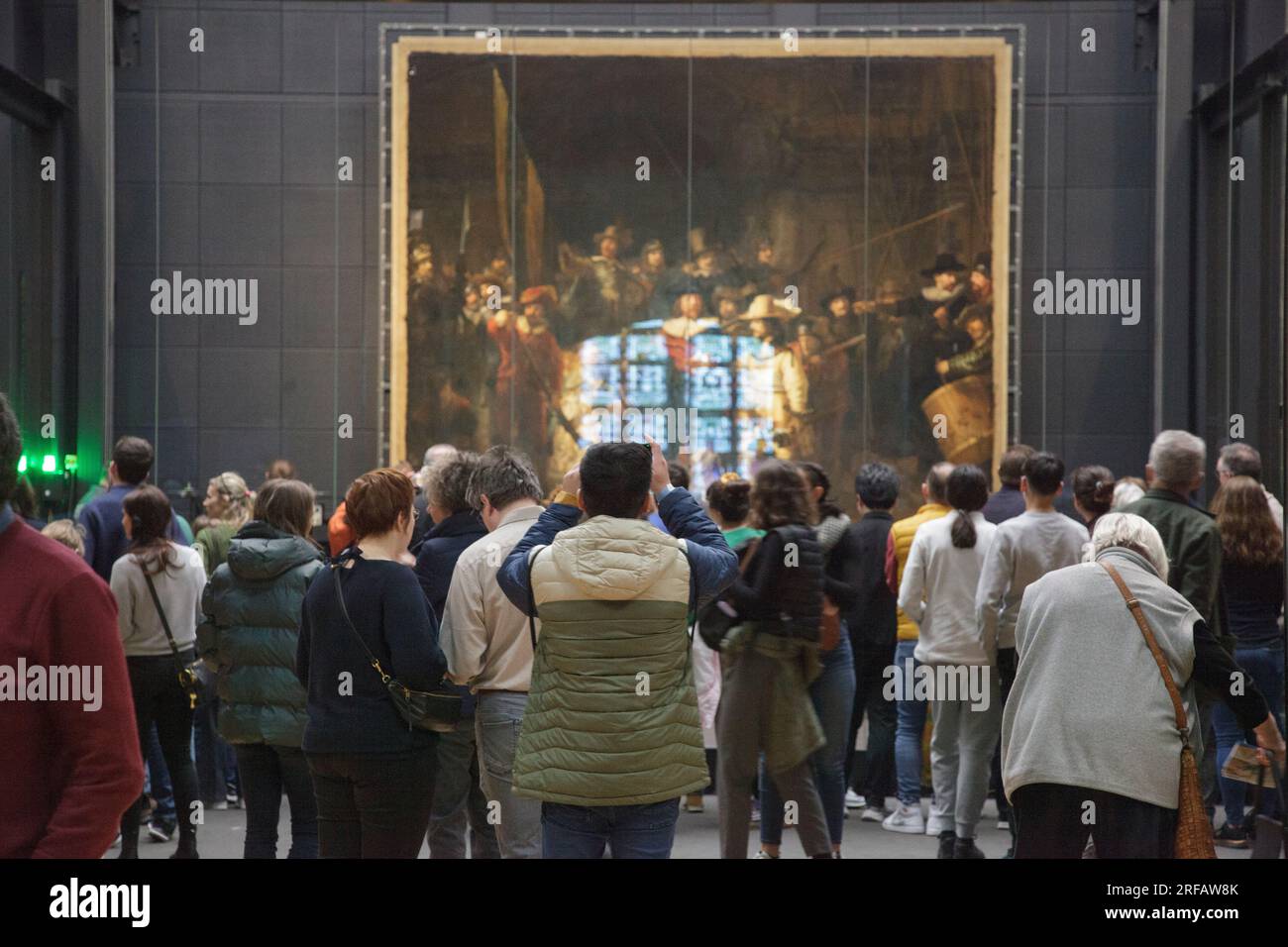 I visitatori si affollano intorno alla Ronda notturna di Rembrandt nel Rijksmuseum di Amsterdam Foto Stock