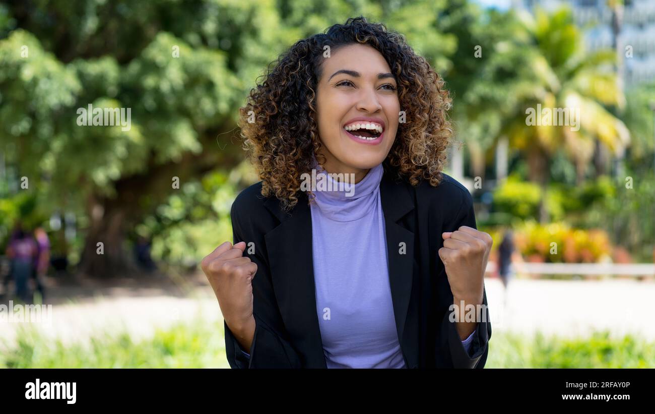 Donna d'affari latinoamericana di successo con un blazer blu all'aperto in città d'estate Foto Stock