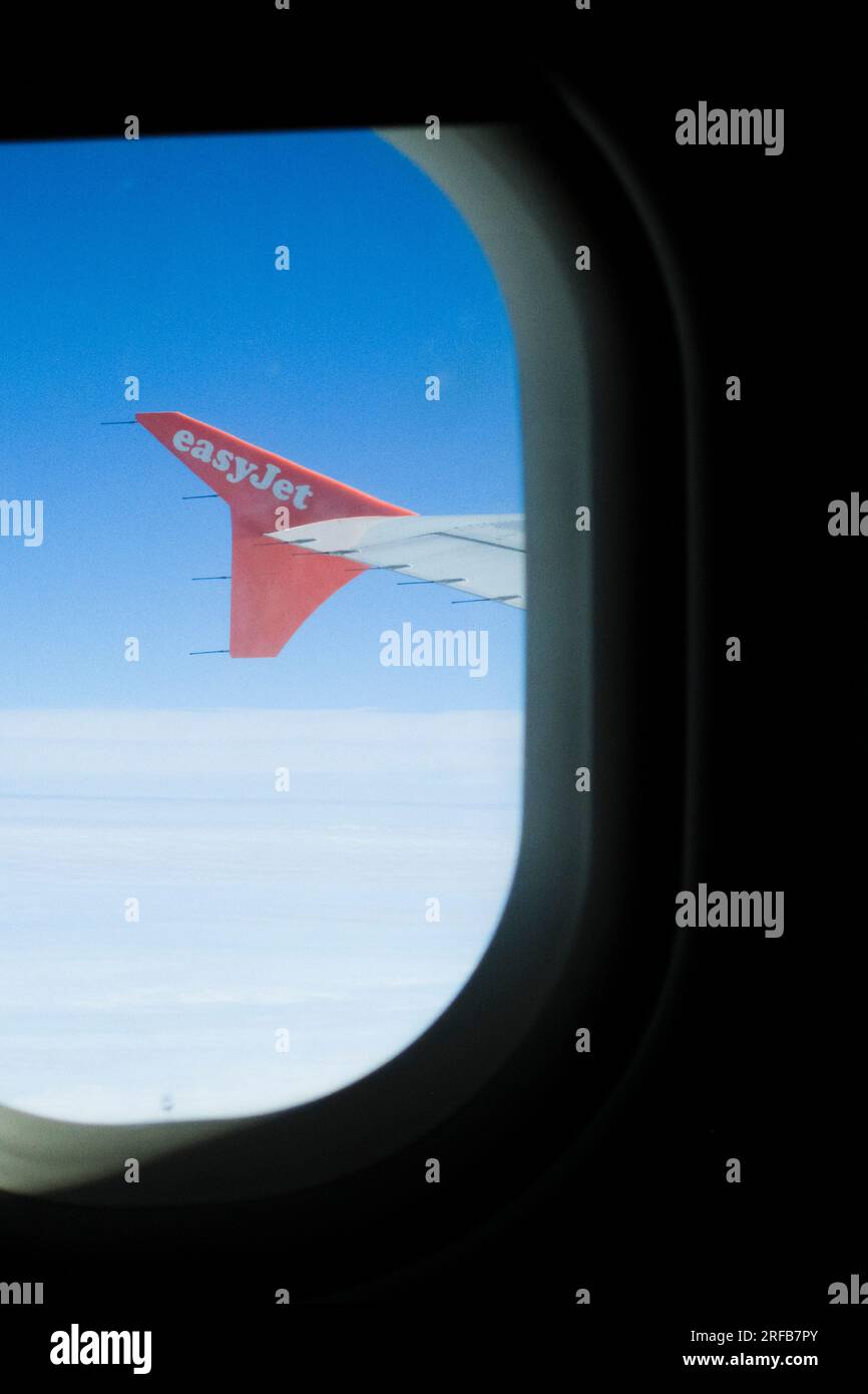 Vista dalla finestra di un aereo o di un aereo di linea che mostra l'ala del jet e un cielo blu profondo. Foto Stock