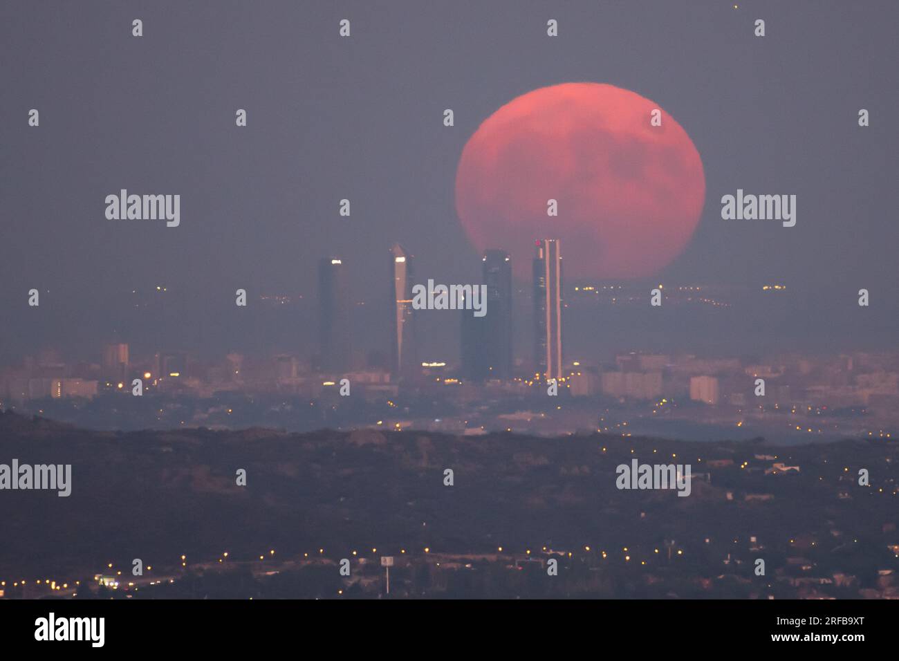 Madrid, Spagna. 1 agosto 2023. La luna piena di agosto, conosciuta come Sturgeon Moon, sorge sullo skyline con i grattacieli della zona commerciale Four Towers di Madrid. Crediti: Marcos del Mazo/Alamy Live News Foto Stock