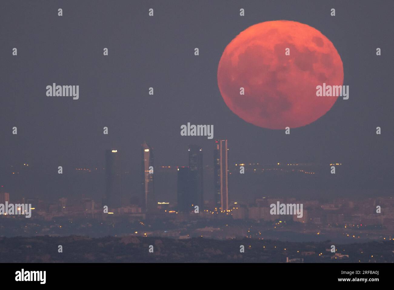 Madrid, Spagna. 1 agosto 2023. La luna piena di agosto, conosciuta come Sturgeon Moon, sorge sullo skyline con i grattacieli della zona commerciale Four Towers di Madrid. Crediti: Marcos del Mazo/Alamy Live News Foto Stock