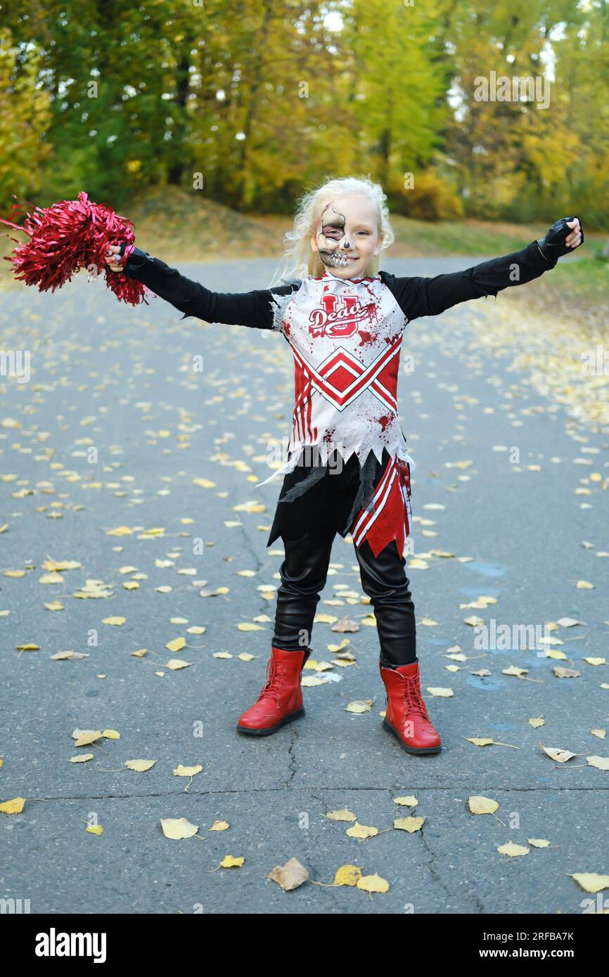 Una ragazza con un costume da cheerleader e un trucco a mezza faccia sotto  forma di scheletro celebra Halloween. Foto verticale Foto stock - Alamy