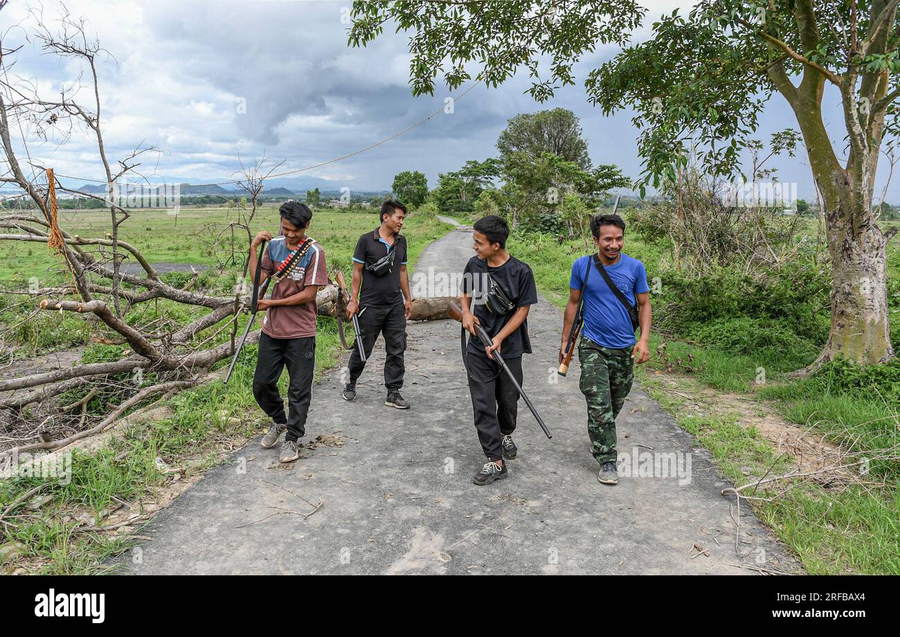 I membri della tribù Kuki-Zo camminano al checkpoint di Kangvai a guardia dei villaggi tribali vicini nel distretto di Churachandpur nello stato nordorientale di Manipur. I giovani delle tribù Kuki-Zo a Manipur hanno preso le armi per proteggere il loro villaggio da minacce esterne, in particolare dai loro nemici, i Meiteis, che vivono nella valle. Con un forte senso di unità e determinazione a proteggere la loro terra, i giovani del villaggio hanno formato una forza di difesa e si sono armati di fucili a canna singola approvati dal governo di Manipur. Gli scontri tra le tribù Meitei e Kuki-Zo continuano anche af Foto Stock