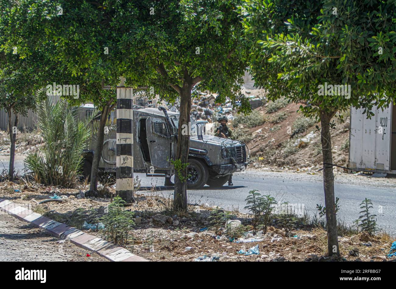 Jordan Valley, Palestina. 2 agosto 2023. Un soldato israeliano sta di guardia accanto alla pattuglia militare durante l'assedio della zona vicino al sito dell'attacco sparatorio a un'auto di coloni ebrei, vicino all'insediamento di Hamra nella Cisgiordania settentrionale. Un'auto in eccesso ha aperto il fuoco su un'auto appartenente ai coloni vicino all'insediamento di al-Hamra, ferendoli. L'esercito israeliano continua a circondare l'area per arrestare il colpevole. Credito: SOPA Images Limited/Alamy Live News Foto Stock