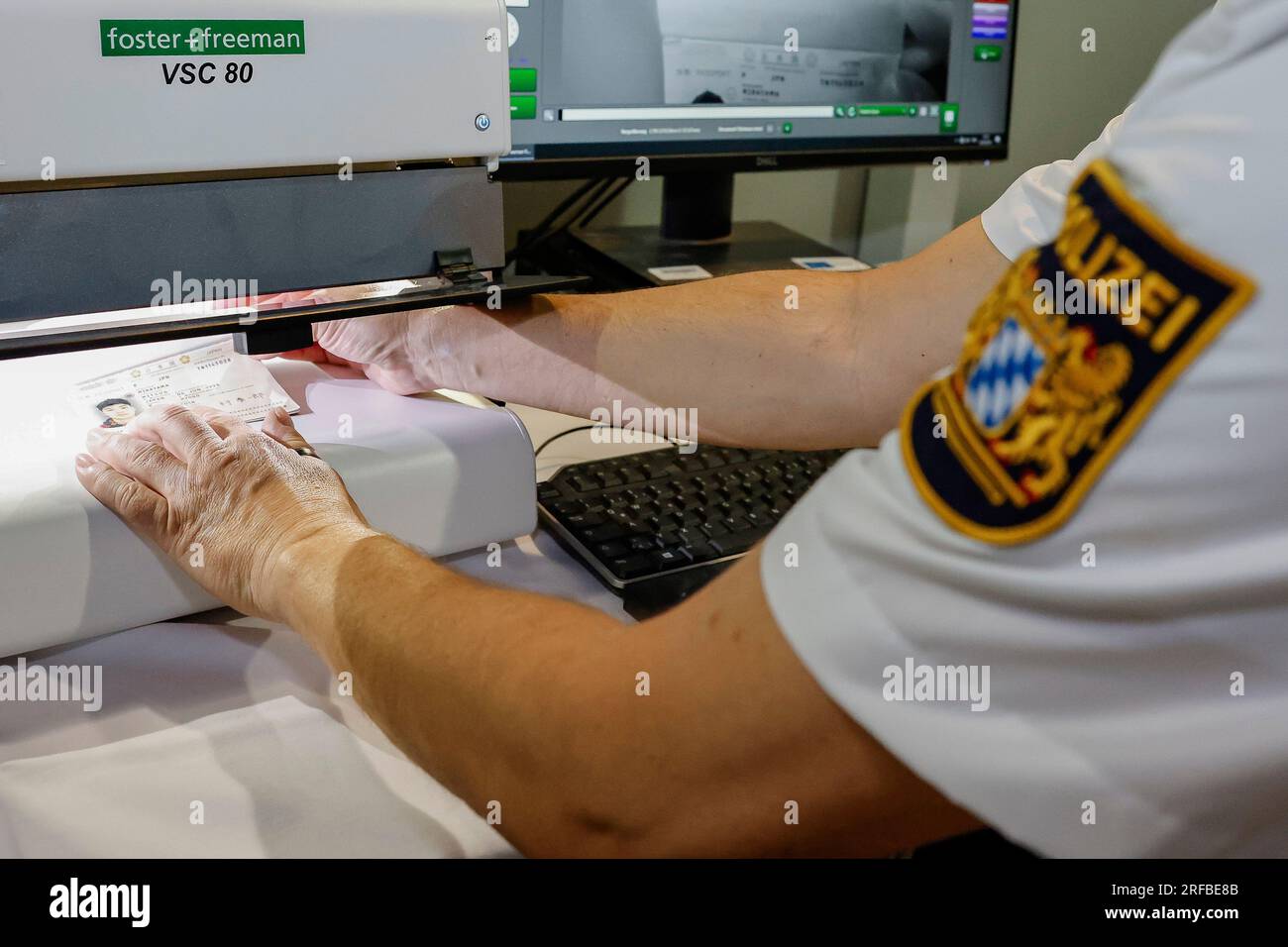 Norimberga, Germania. 2 agosto 2023. Un agente di polizia della polizia di frontiera bavarese controlla l'autenticità di una carta d'identità all'aeroporto, si scopre che è un falso. La polizia di frontiera ha iniziato il suo lavoro il 1 luglio 2018. Credito: Daniel Löb/dpa/Alamy Live News Foto Stock