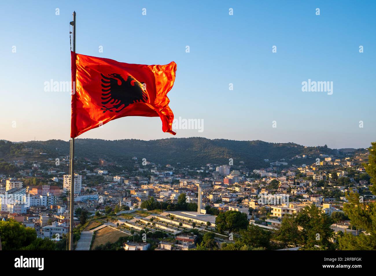 L'Albania bandiera. Bandiera albanese su un pennone sventola su un luminoso  cielo blu sullo sfondo Foto stock - Alamy