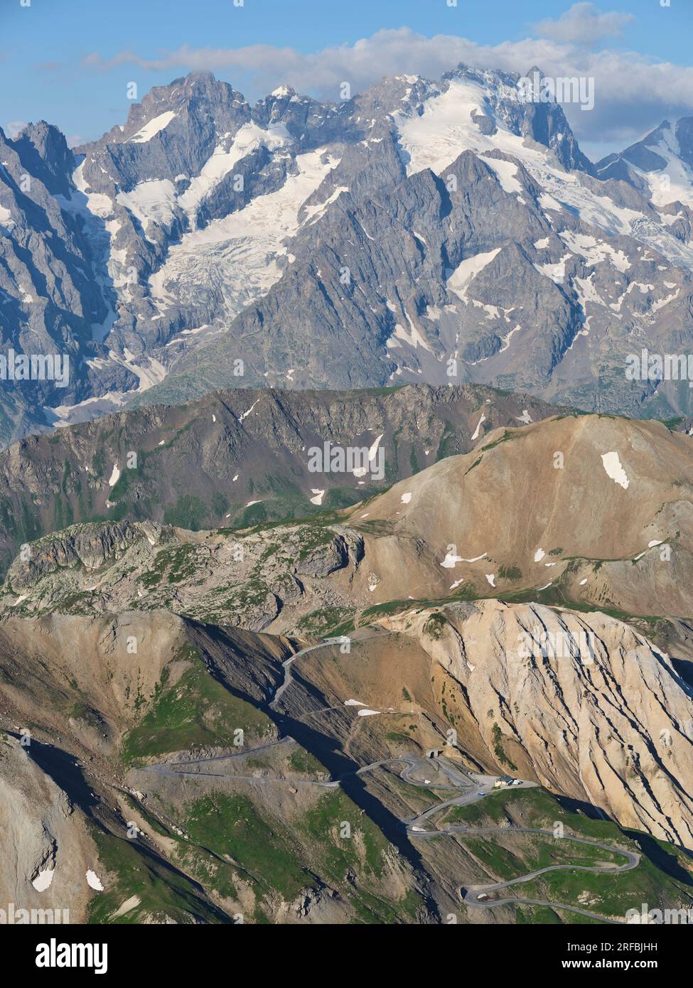 VISTA AEREA. Col du Galibier (2642 m) con il Meije (3984 m) per uno sfondo maestoso. Tra le Monêtier-les-Bains e Valloire. Francia. Foto Stock